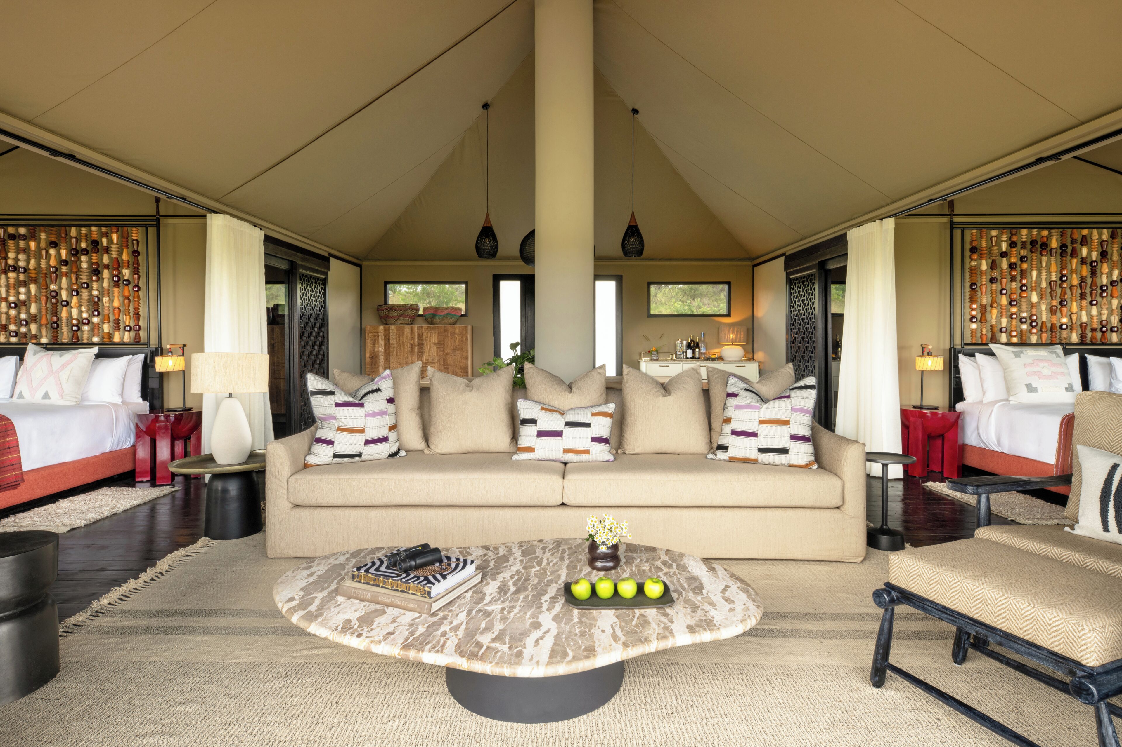 A spacious room with a large sofa, a coffee table, and a bed with multiple pillows.