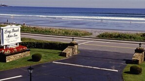 A parking lot leading to a beachside motel with a sign reading "Long Beach Motor Inn." - Long Beach Motor Inn (York Beach)