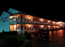 Um motel com estrutura em dois andares, várias varandas e estacionamento.