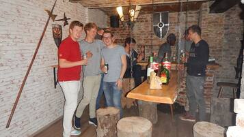 A rustic bar setting with exposed brick walls, wooden beams, and a wooden table with drinks.
