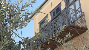 A building with a balcony featuring ornate metal railings and a stone facade.