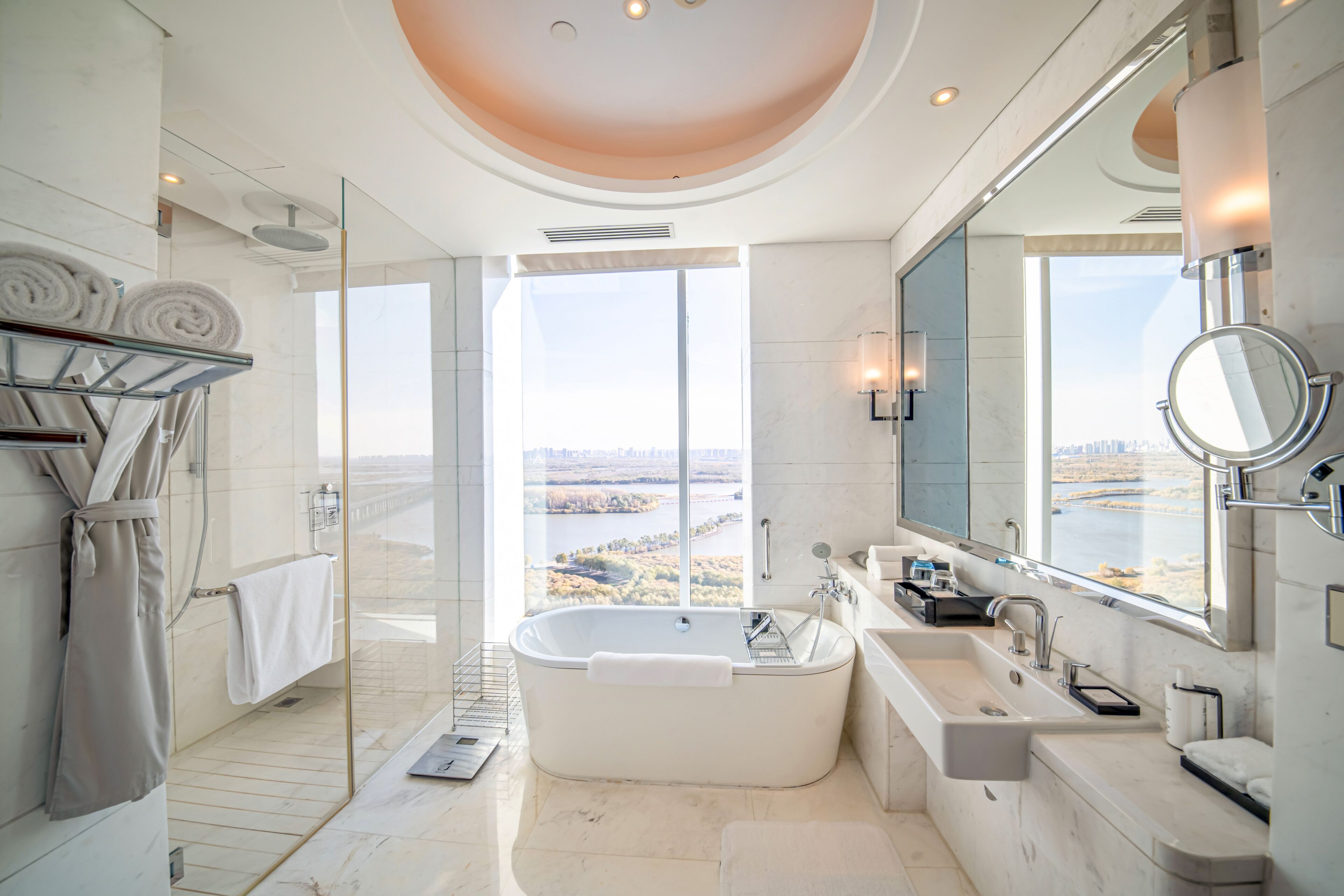A modern bathroom with a large bathtub, a walk-in shower, and a glass-enclosed shower area.