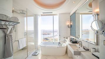 A modern bathroom with a large bathtub, a walk-in shower, and a glass-enclosed shower area.