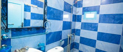 Un baño con lavamanos, inodoro y ducha.