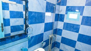 Une salle de bain avec un lavabo, des toilettes et une douche.