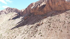 Un paysage montagneux accidenté, caractérisé par un terrain rocheux et une végétation clairsemée.