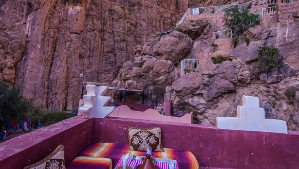 Un espace extérieur aménagé en hauteur, avec des sièges, offrant une vue sur un canyon rocheux.