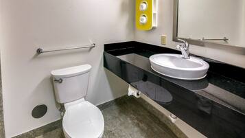 A bathroom with a toilet, a sink, and a mirror.