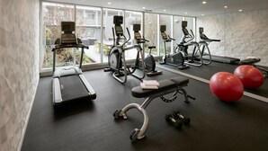 A gym with treadmills, elliptical machines, a bench, and red exercise balls. - Hotel Lucent (Menlo Park)