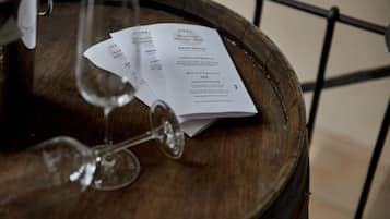 Un barril de madera con un menú y dos copas de vino sobre una mesa.
