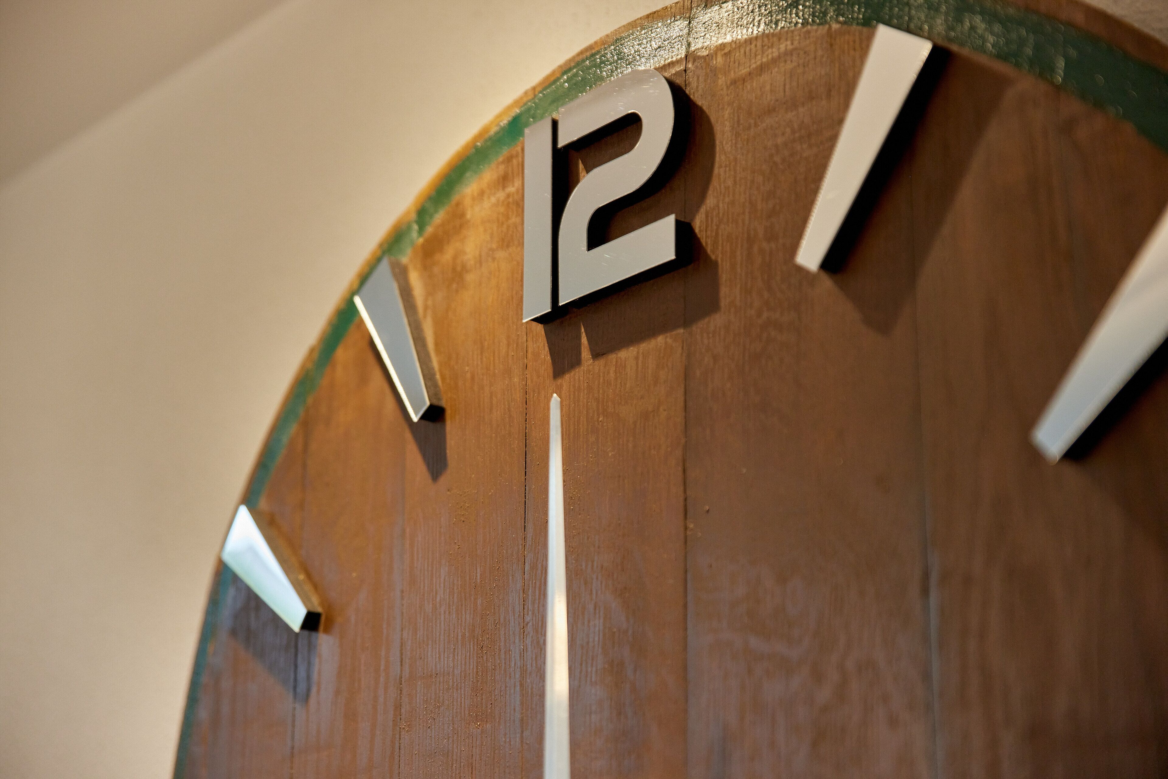 Une horloge murale en bois au design minimaliste, avec de grands chiffres bien visibles.