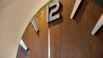 Une horloge murale en bois au design minimaliste, avec de grands chiffres bien visibles.