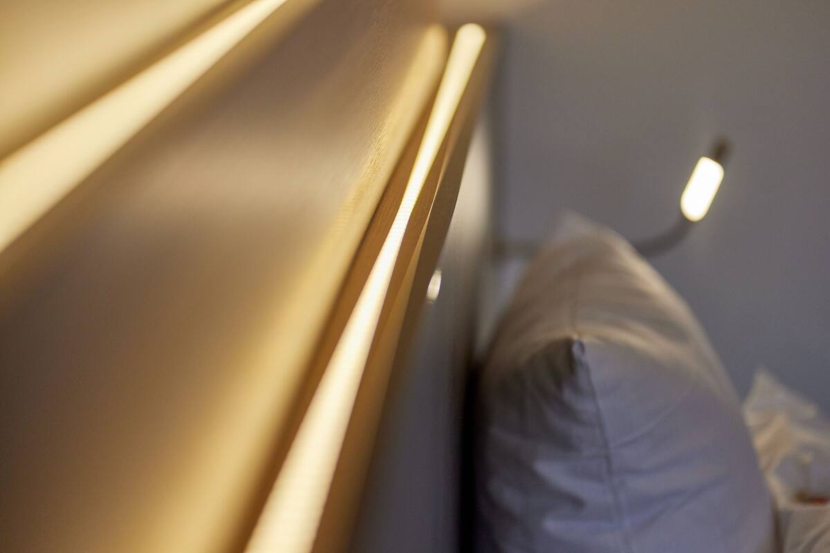 Un gros plan d’un lit avec une tête de lit et un oreiller.