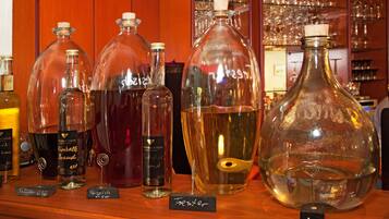Variedad de botellas de vidrio con etiquetas, algunas con tapones de corcho, sobre un estante de madera.