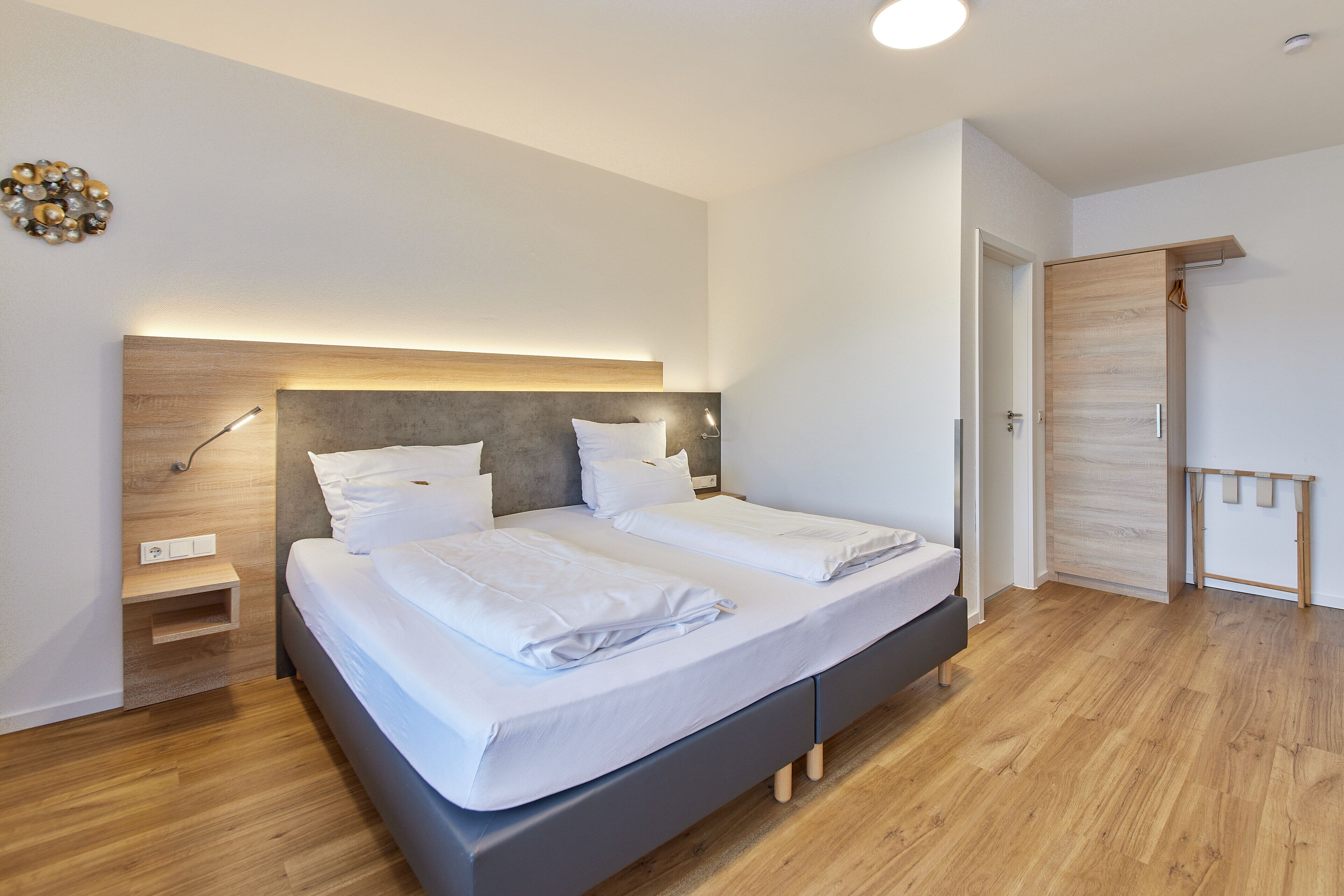 Ein modernes Schlafzimmer mit Bett, Nachttischen und einem Kleiderschrank.