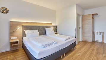 Ein modernes Schlafzimmer mit Bett, Nachttischen und einem Kleiderschrank.