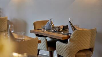 Een eettafel met stoelen, een wijnglas en een menukaart.