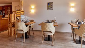 Comedor con muebles de madera, máquina de café y una lámpara fijada a la pared.