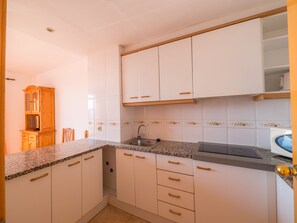 Apartamento, 2 quartos | Cozinha americana privada | Geladeira, micro-ondas, talheres/pratos/utensílios de cozinha
