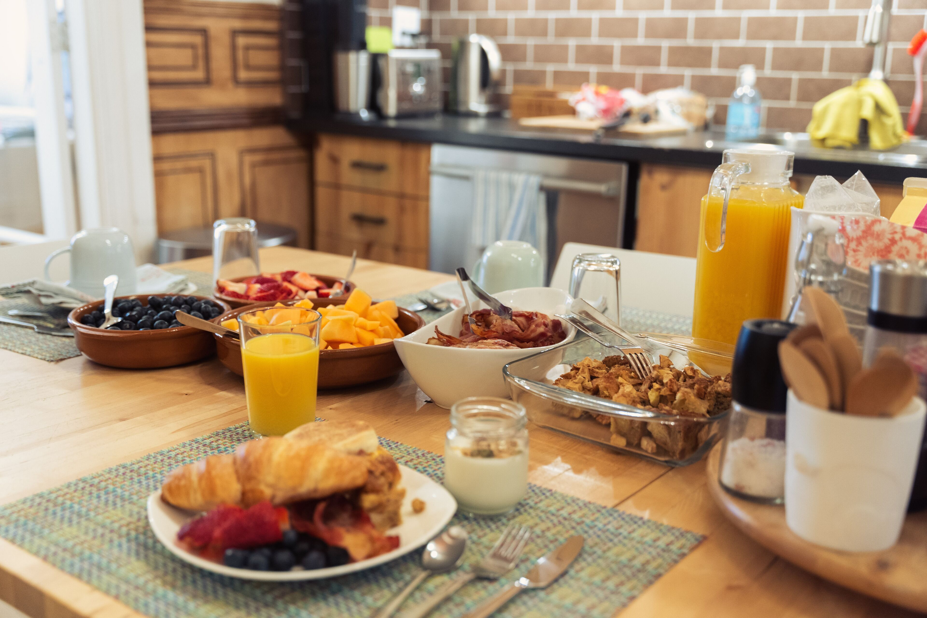 A breakfast table with various food items and drinks.