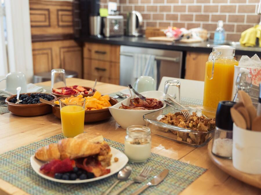 A breakfast table with various food items and drinks.