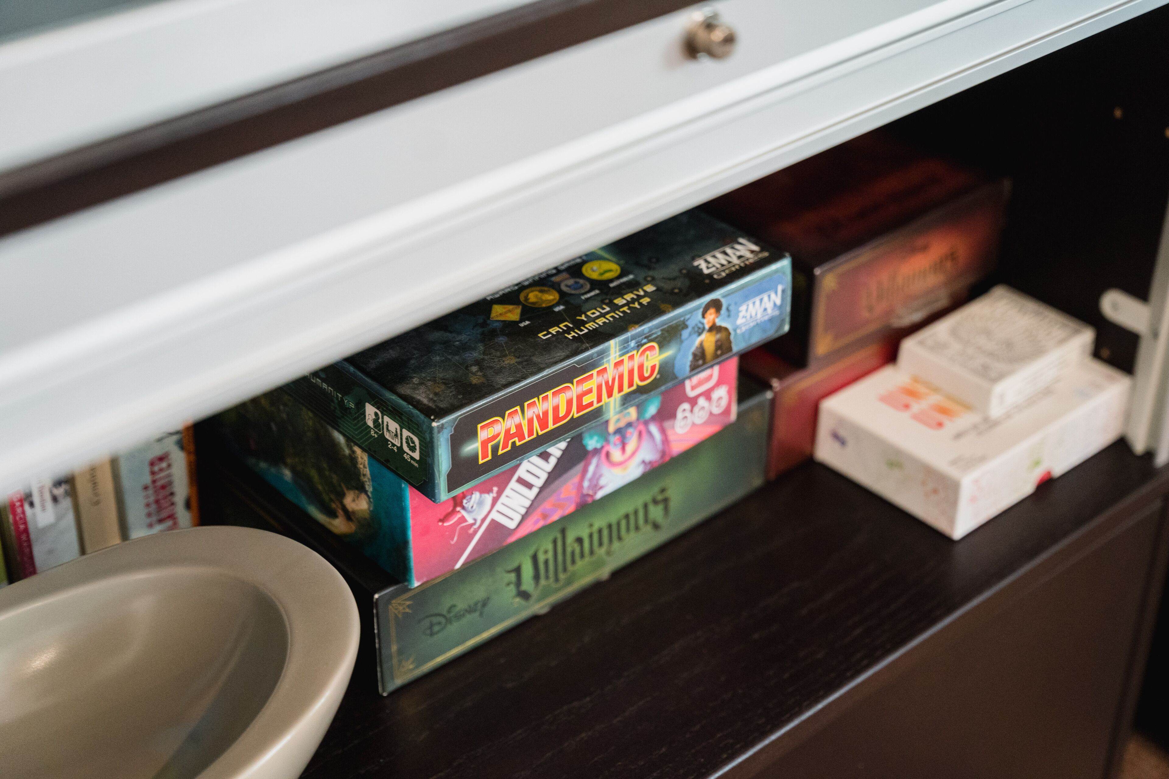 A shelf with board games, including Pandemic and Villains.