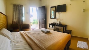 A hotel room with a bed, a desk, a chair, a TV, and a window with curtains. - Mali-Mali Beach Resort (Langkawi)