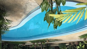 A swimming pool with a tiled edge and a variety of hanging plants around it. - Mali-Mali Beach Resort (Langkawi)