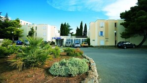 A building with a sign reading "Villa Lovorka" and several parked cars in front. - Villa Lovorka - Hotel Resort Drazica (Krk)