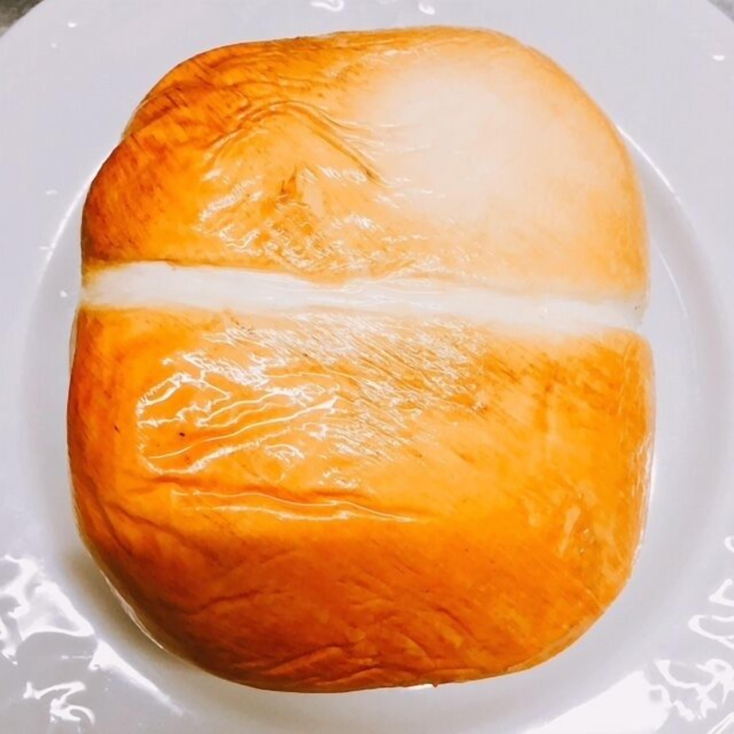 A loaf of bread with a golden-brown crust and a white line down the middle.
