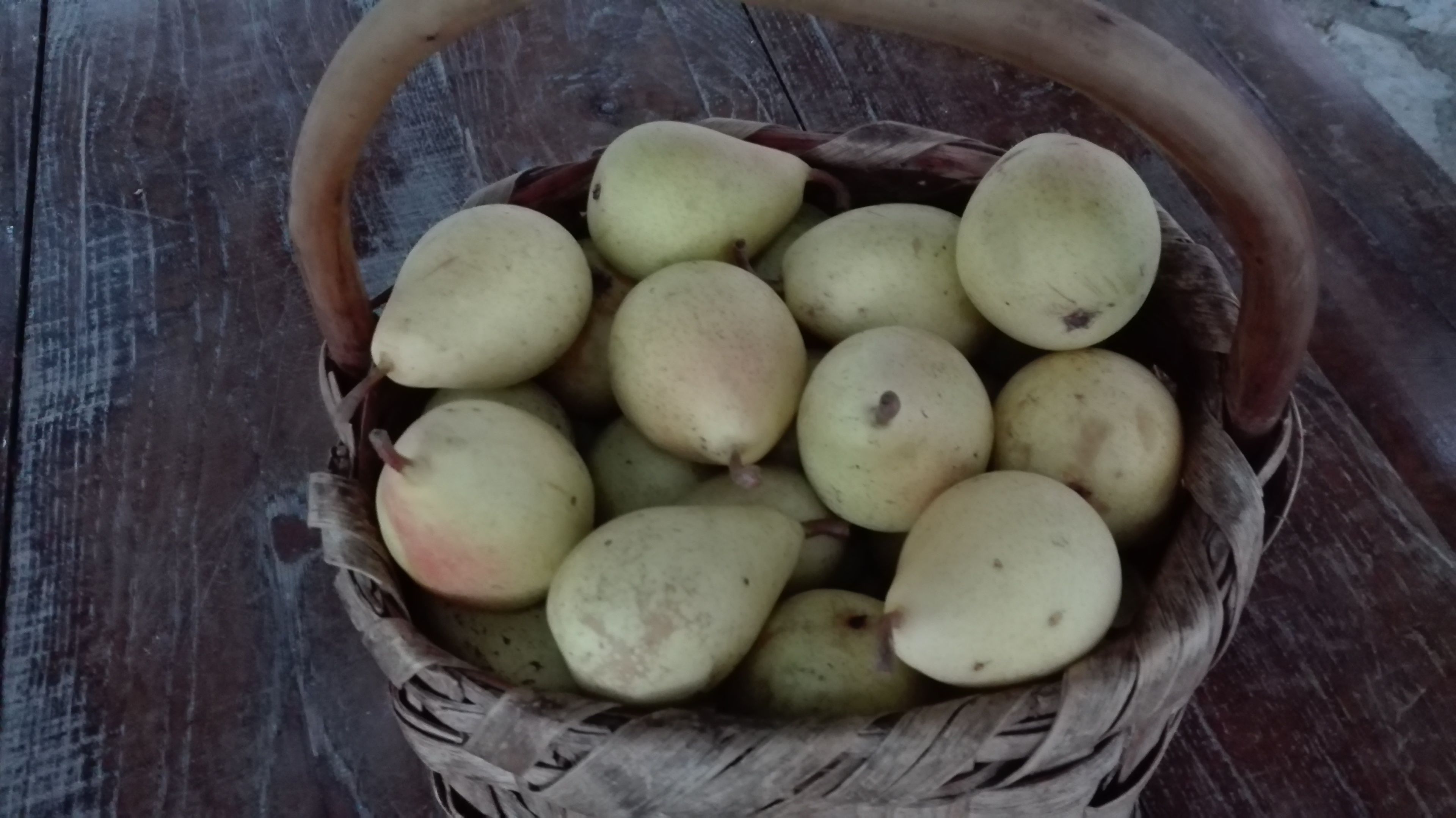 Uma cesta de frutas sobre uma superfície de madeira.