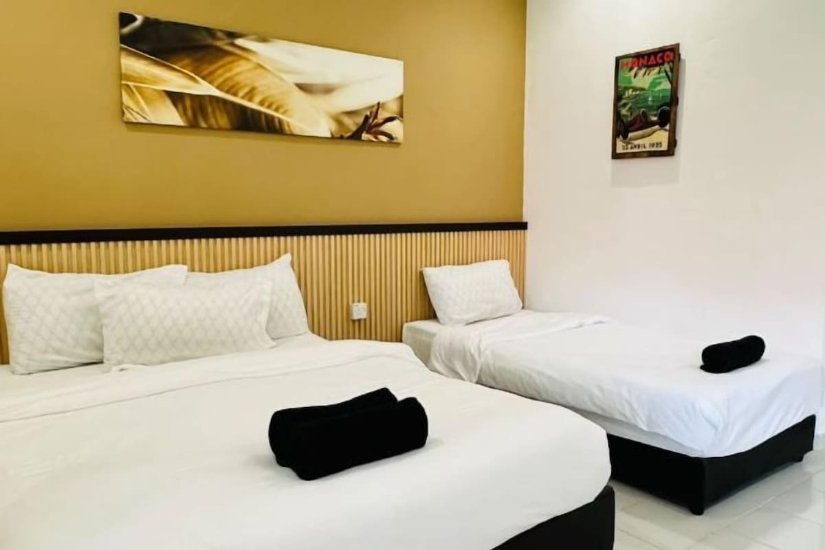 A hotel room with two beds, a wooden headboard, and a wall-mounted artwork.