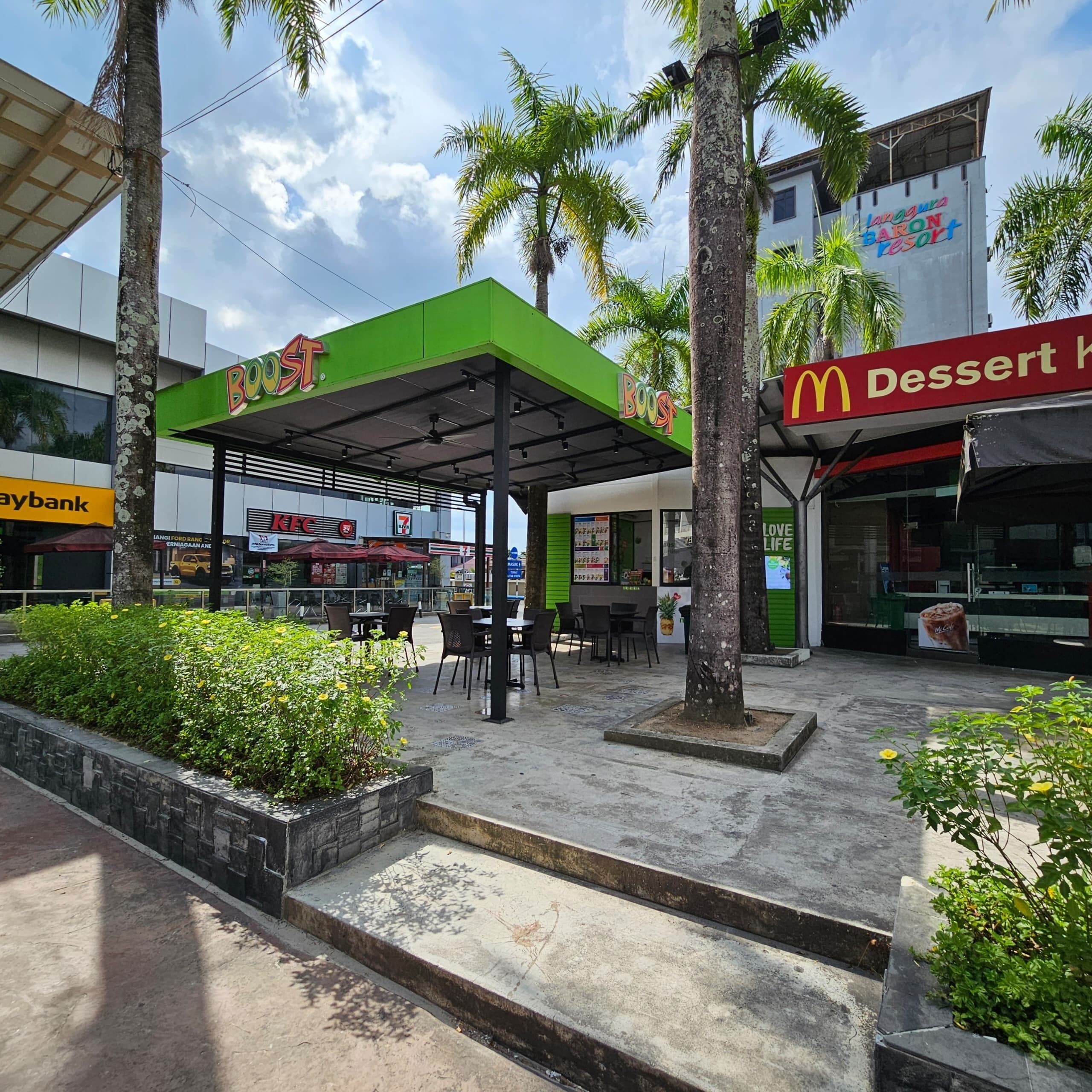 A commercial area with a green-roofed KFC, a McDonald's, and a Boost store.