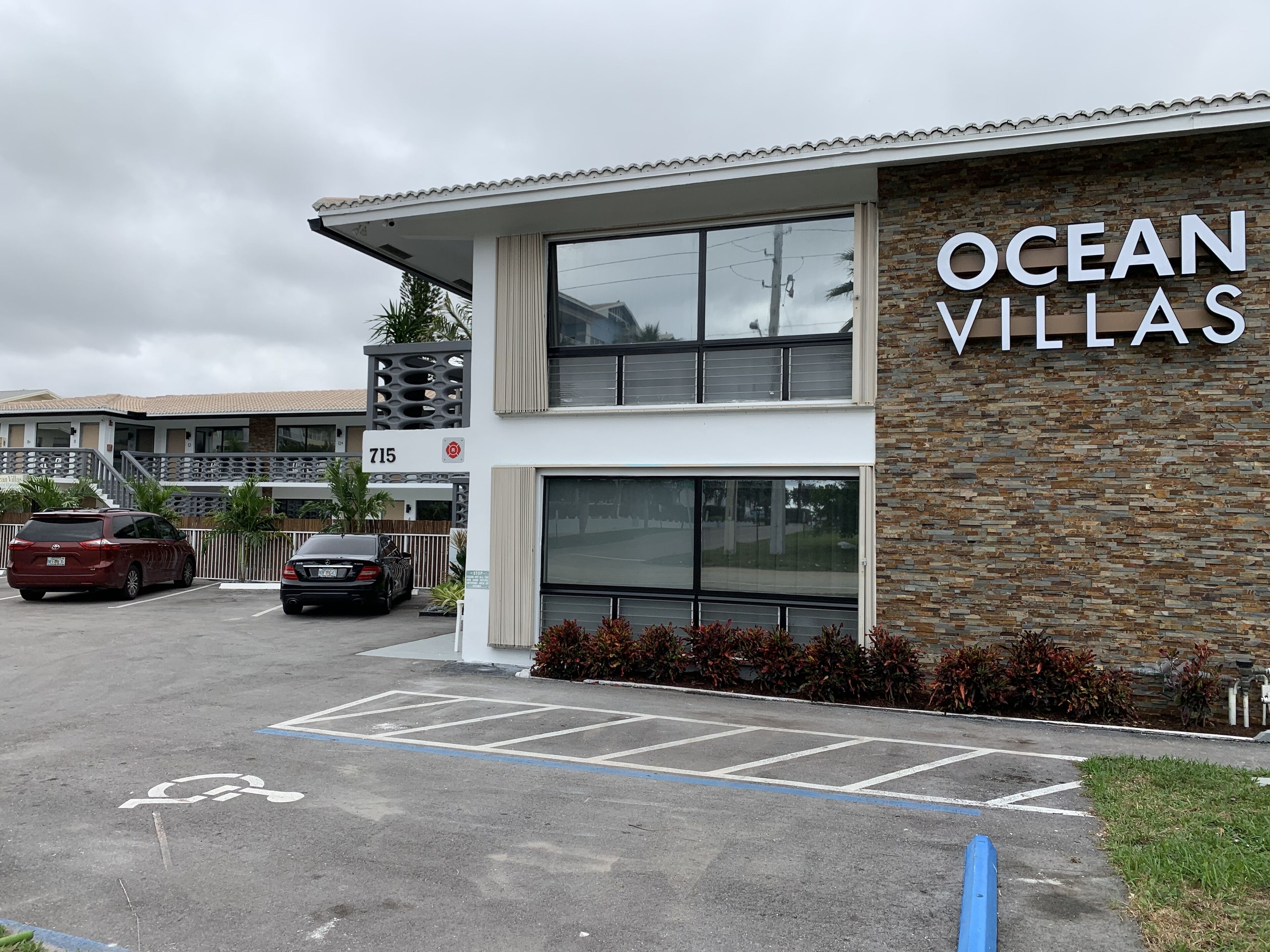 A building labeled "Ocean Villas" with a parking lot and a wheelchair-accessible parking space.