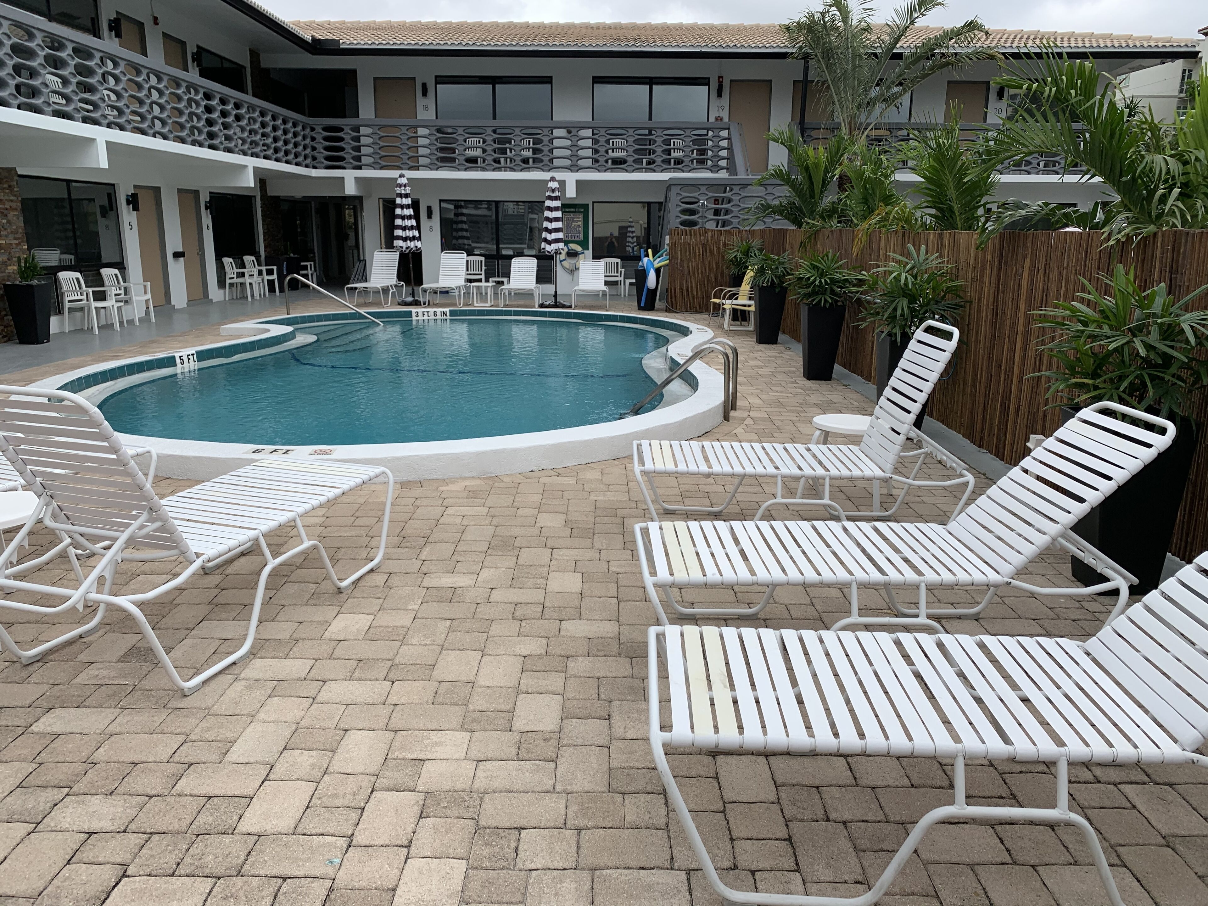 A pool area with lounge chairs and a pool.