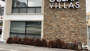 Un edificio con un letrero que dice "OCEAN VILLAS" y fachada de piedra.