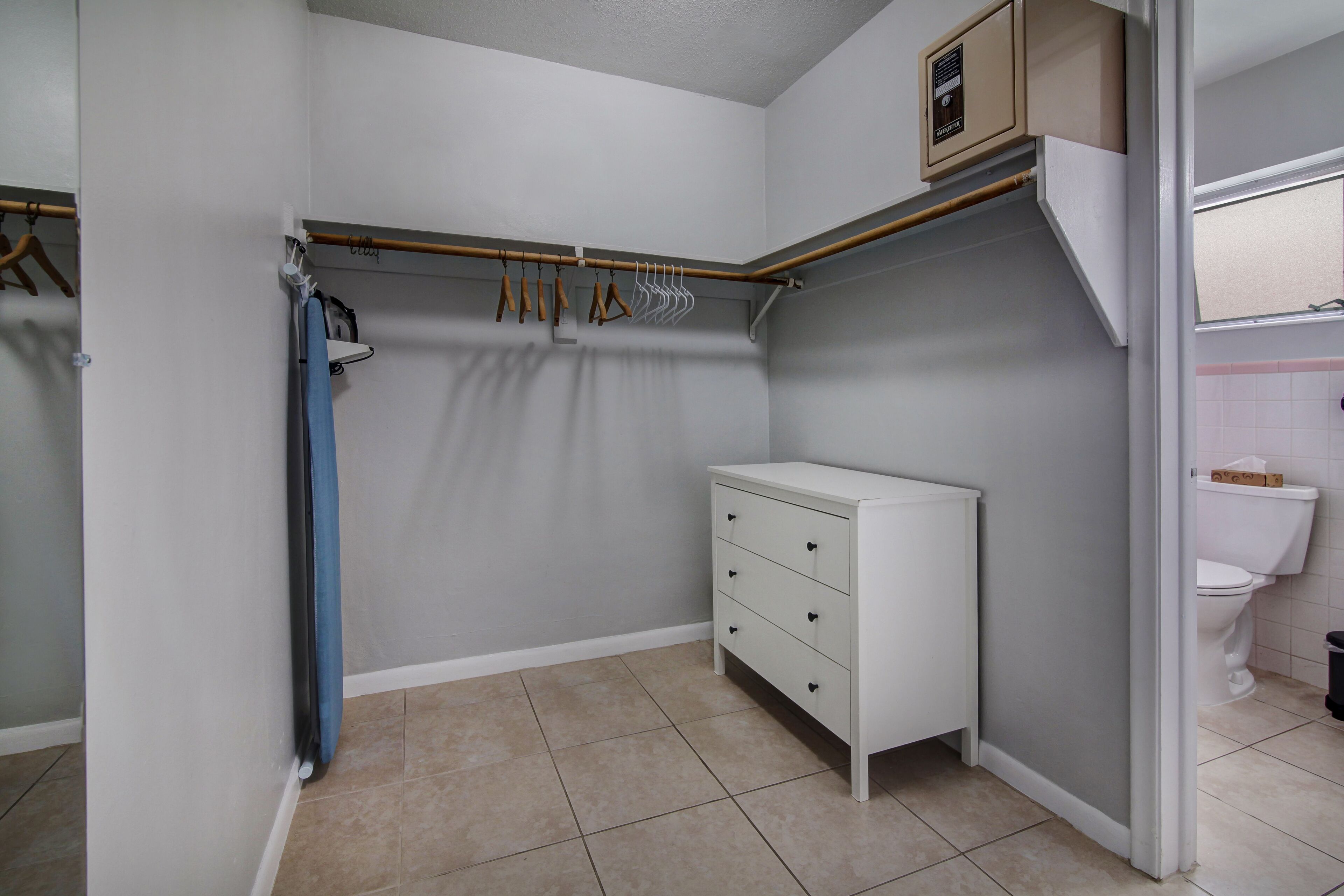 A small, clean bathroom with a toilet, a sink, and a storage cabinet.
