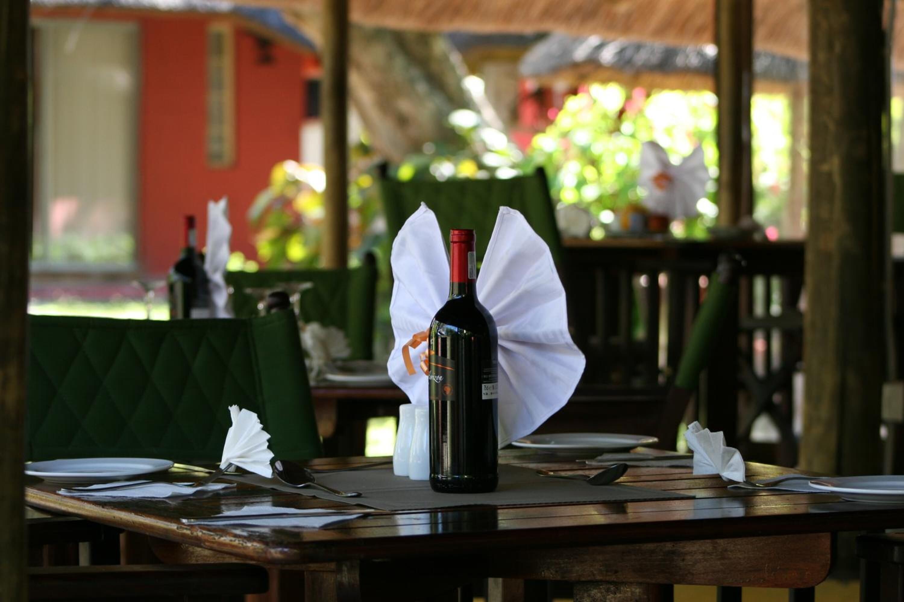 Una mesa de comedor con una botella de vino, una servilleta y una copa.