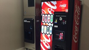 Een automaat met een Coca-Cola logo en een waterdispenser ernaast.