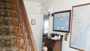 A staircase with patterned carpet leading to a room with a desk, a map, and a basket of toys. - Candlebay Inn (Freeport)