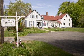 Ein weißes Gebäude mit rotem Dach, ein Schild mit der Aufschrift 'Candlebay Inn' und eine amerikanische Flagge.