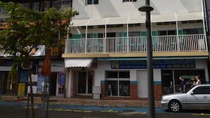 A multi-story hotel with a balcony on the second floor, a sign indicating a restaurant, and a visible entrance. - Bayfront Hotel (Fort-de-France)