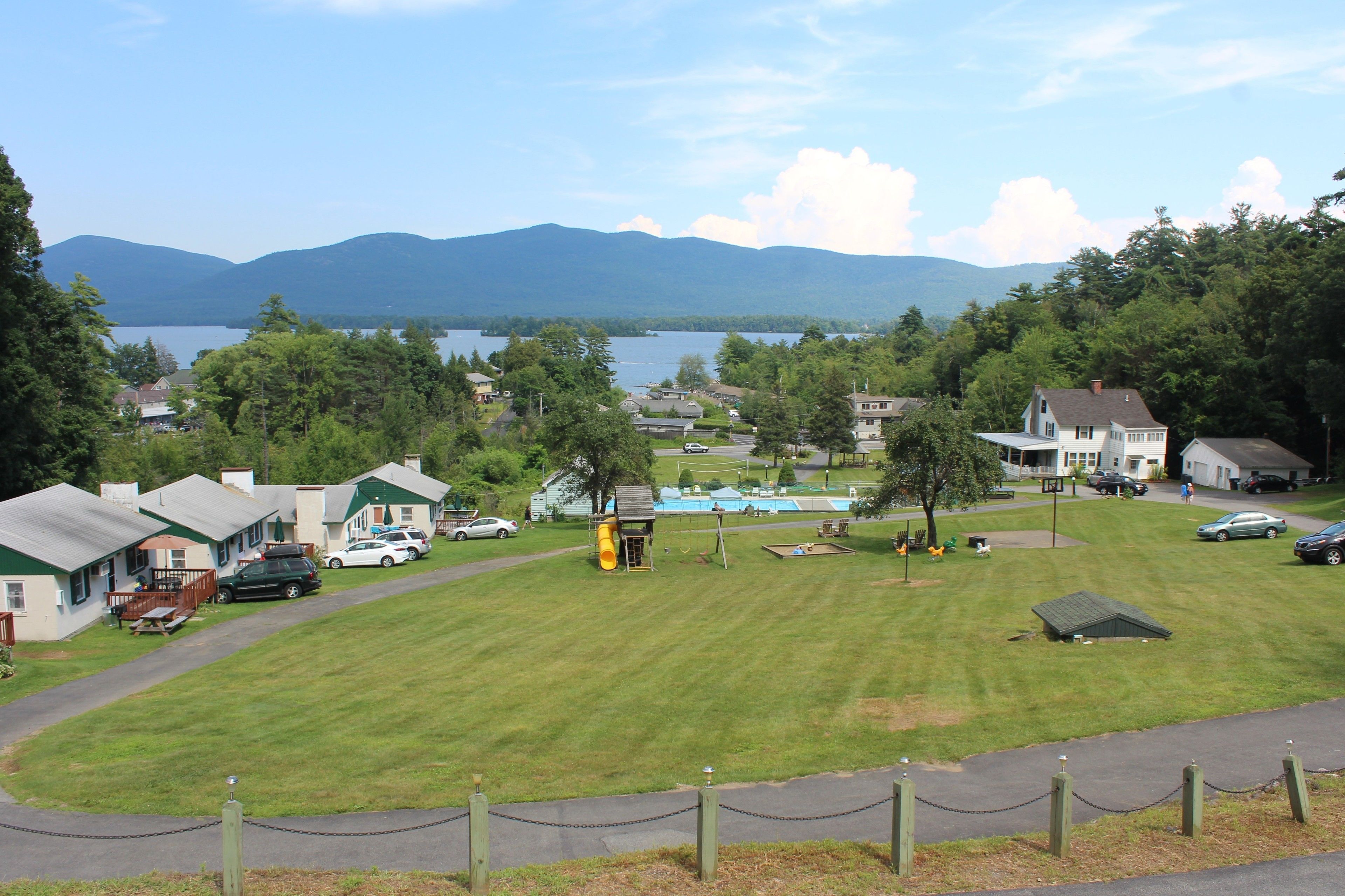 Zona residencial con casas, un parque infantil y un lago.