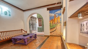 A room with a purple bench, a tiled floor, and a mural of a castle.