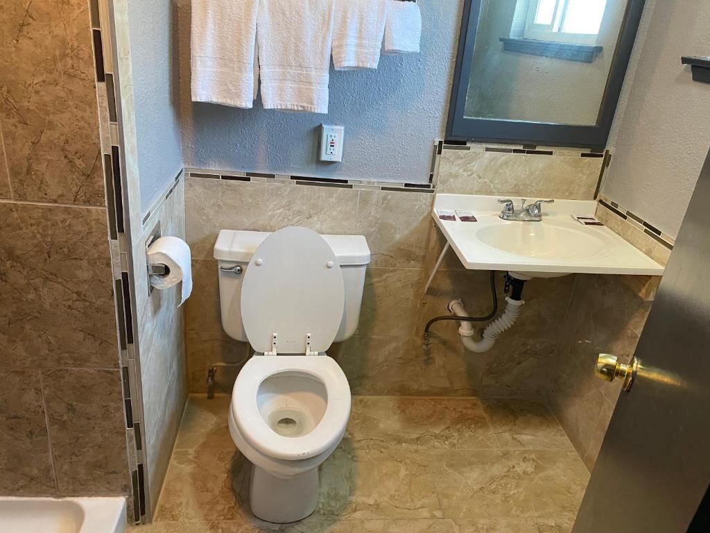 A bathroom with a toilet, sink, and towel rack.
