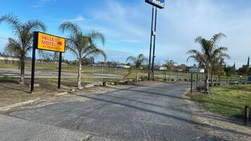 Señal de motel con flechas direccionales y vista de la calle.