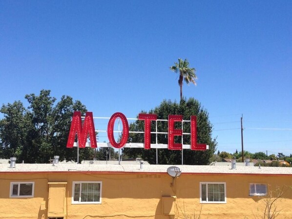 Une enseigne de motel avec le mot « MOTEL » écrit en grandes lettres rouges sur le bâtiment.