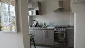 Una cocina con estufa, microondas y armarios.