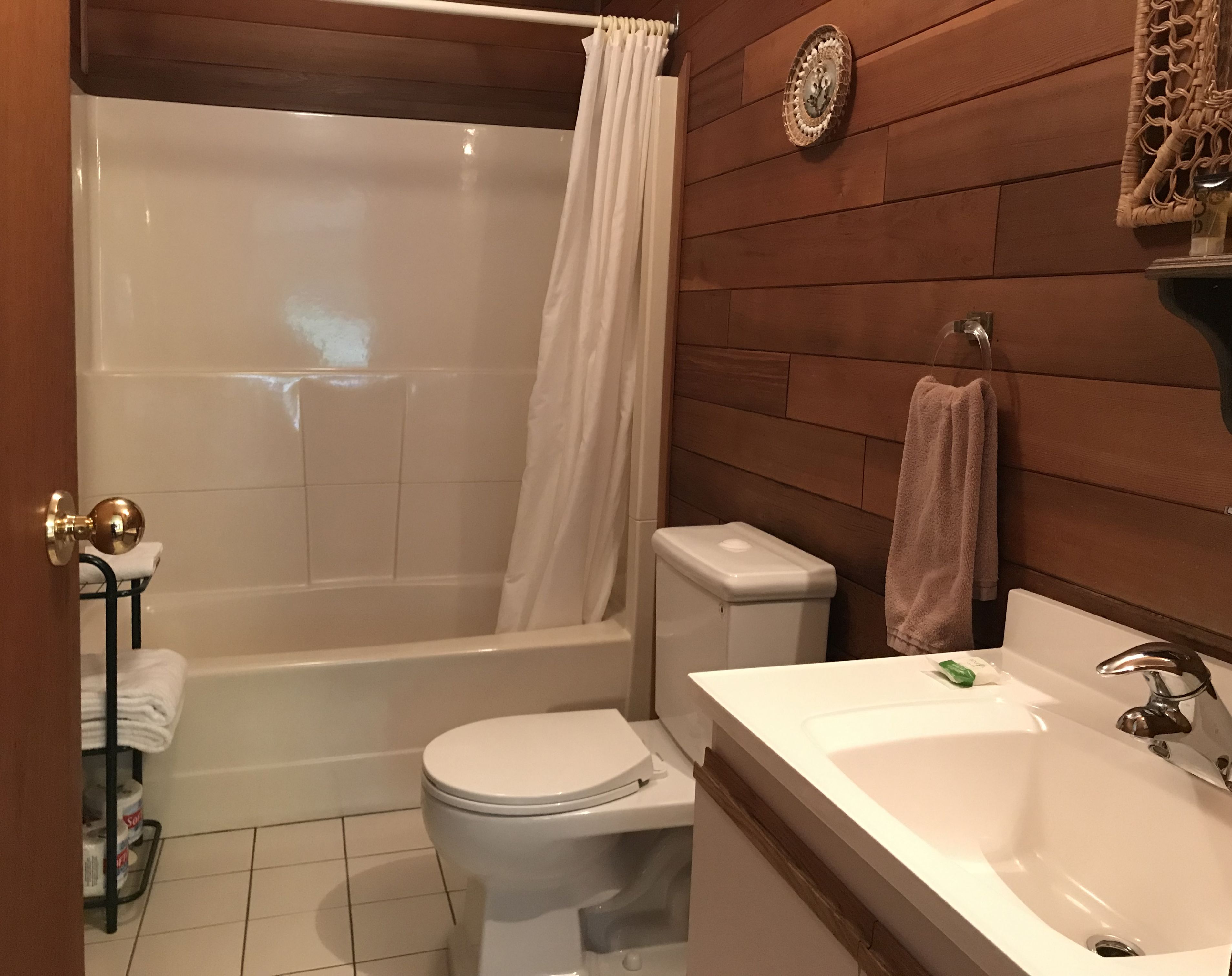 A bathroom with a bathtub, toilet, and sink.