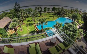 A pool area with a clear view of the water, surrounded by greenery and palm trees. - Plumeria Private Villa (Ho Chi Minh City)